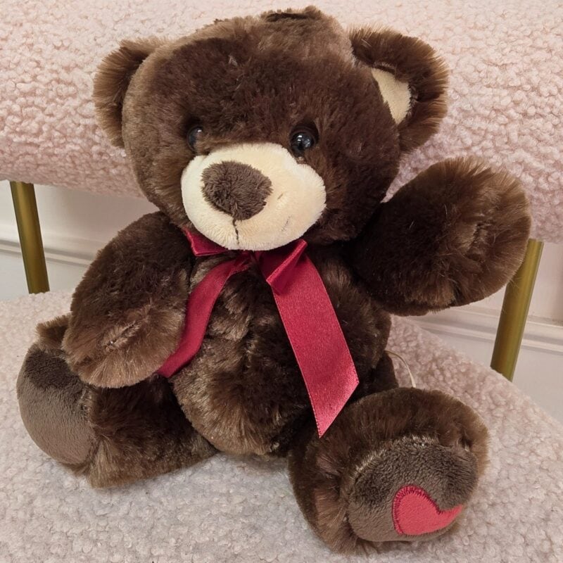 Osito de peluche chocolate con cinta satinada vino y corazón rojo en el pie