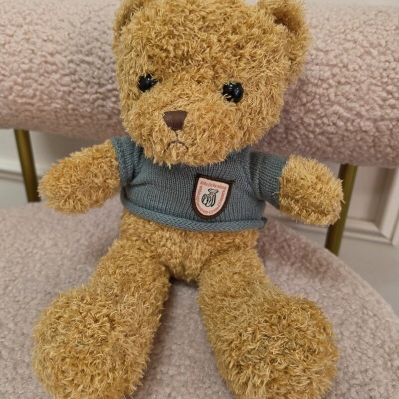 Osito de peluche dorado rizado sentado