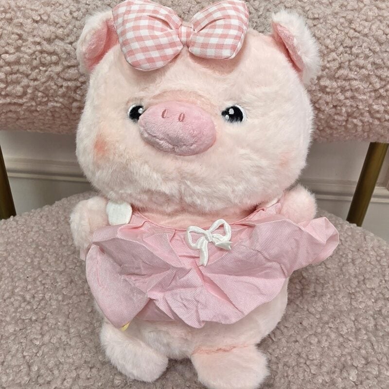 Cerdita de peluche rosada con vestido de volantes rosado y moño de cuadros