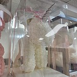 Unicornio de rosas de espuma marfil con cuerno plateado y cinta rosada en caja transparente