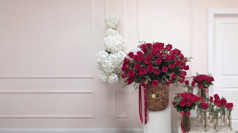 El juego completo para un jet privado en el taller de My Divine Decors en Doral: canasta tejida de rosas rojas sobre un pedestal, un florero de rosas rojas con lazo y rosas sueltas en floreros altos