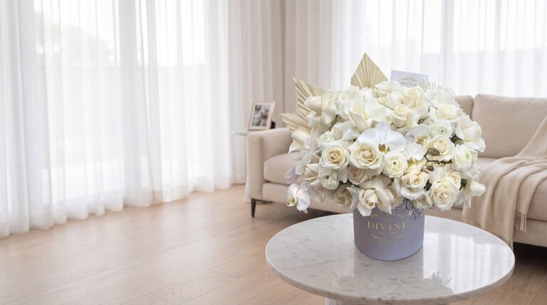 Celine hat box by My Divine Decors with white roses, ranunculus and orchids on a marble table in the quiet living room of a Miami family home
