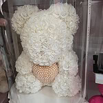 Ivory foam rose bear holding a pearl heart in a clear cylinder