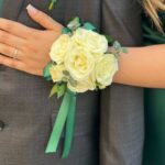 Wrist corsage of ivory spray roses with a green satin ribbon, made by My Divine Decors in Miami for homecoming and prom
