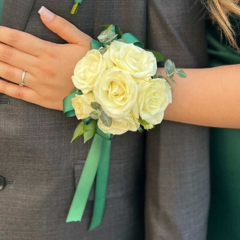 Wrist corsage of ivory spray roses with a green satin ribbon, made by My Divine Decors in Miami for homecoming and prom
